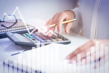 Imagem ilustrativa sobre o setor secundário da economia, mostrando uma pessoa usando uma calculadora e gráficos de crescimento econômico ao fundo, representando seu papel no desenvolvimento industrial.