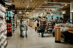 Consumidores fazendo compras em supermercado, destacando a importância de conhecer os Direitos do Consumidor para garantir suas necessidades e direitos ao adquirir produtos.