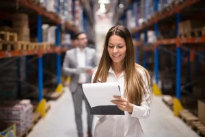 Controle de estoque eficiente em armazém, com profissionais analisando inventário para garantir a saúde financeira da empresa.