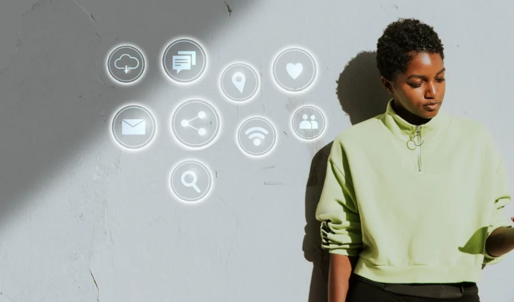 Jovem mulher utilizando smartphone com ícones de tecnologia e marketing digital flutuando ao seu redor, simbolizando dicas para acompanhar as tendências de marketing digital em 2025.