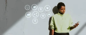 Jovem mulher utilizando smartphone com ícones de tecnologia e marketing digital flutuando ao seu redor, simbolizando dicas para acompanhar as tendências de marketing digital em 2025.
