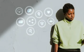 Jovem mulher utilizando smartphone com ícones de tecnologia e marketing digital flutuando ao seu redor, simbolizando dicas para acompanhar as tendências de marketing digital em 2025.