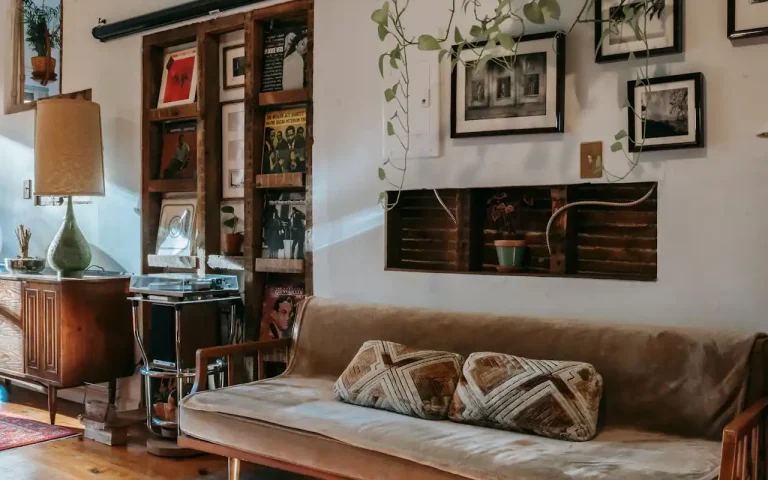 Imagem de sala de estar decorada com ideias de decoração faça você mesmo com materiais reciclados, incluindo prateleiras de madeira, quadros e plantas.