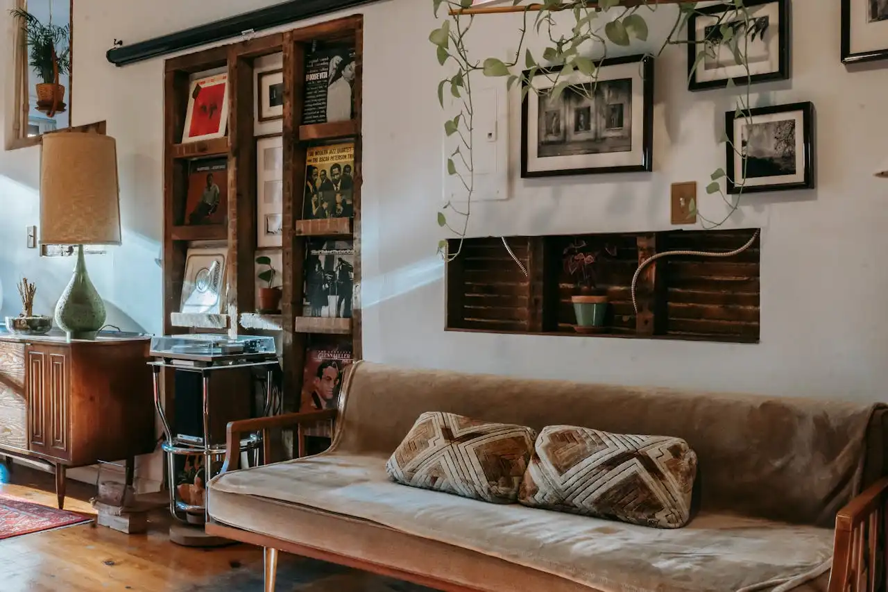 Imagem de sala de estar decorada com ideias de decoração faça você mesmo com materiais reciclados, incluindo prateleiras de madeira, quadros e plantas.